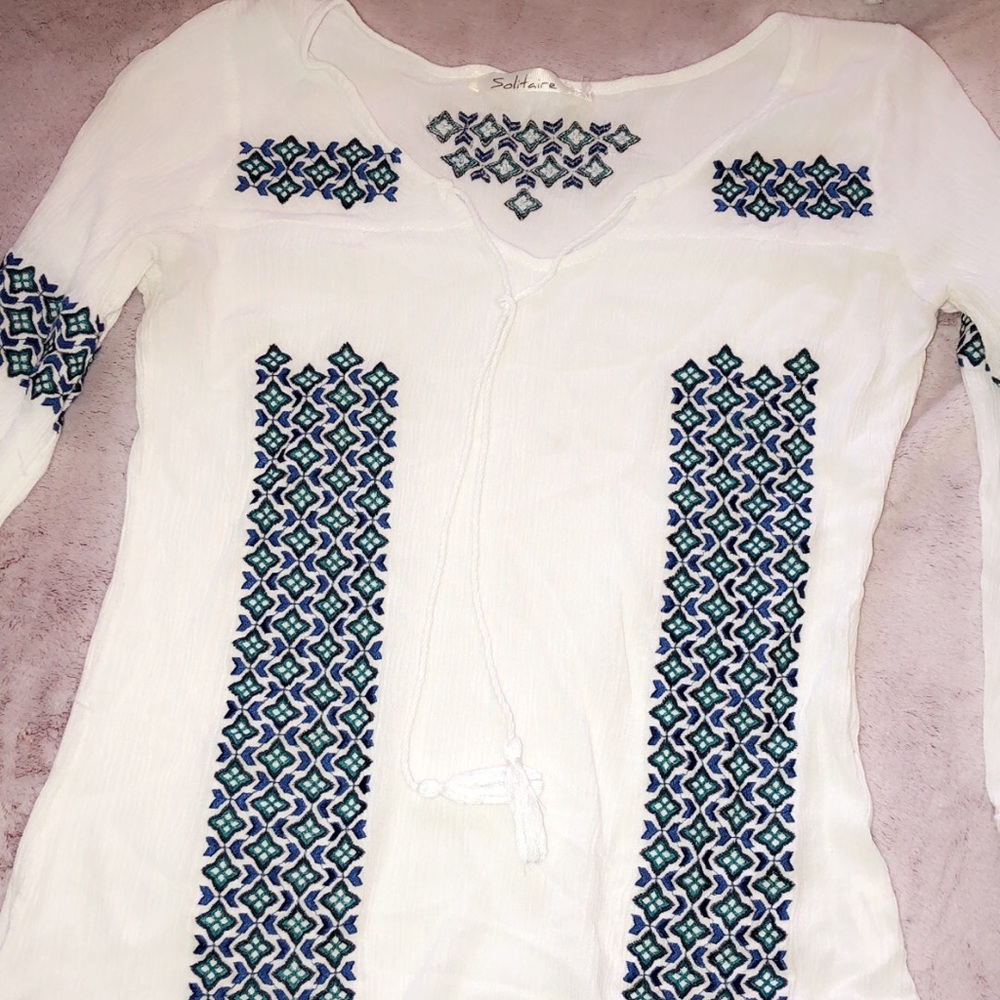 White top with blue and green detailing